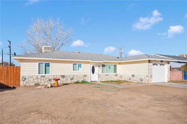 ranch-style home with cooling unit and a garage