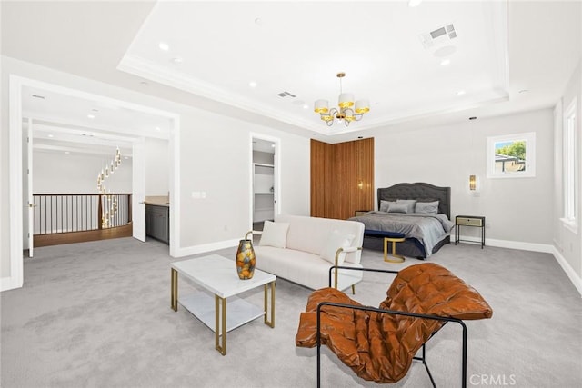 bedroom with a spacious closet, a chandelier, and a tray ceiling