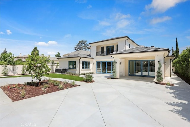 rear view of house with central AC, french doors, and a balcony