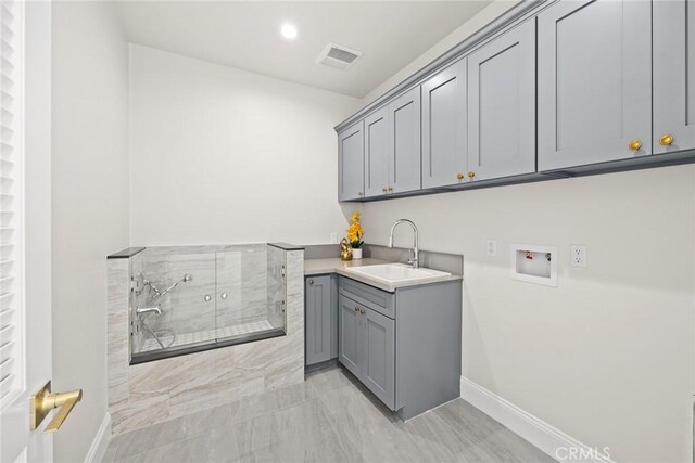 washroom with washer hookup, cabinets, and sink