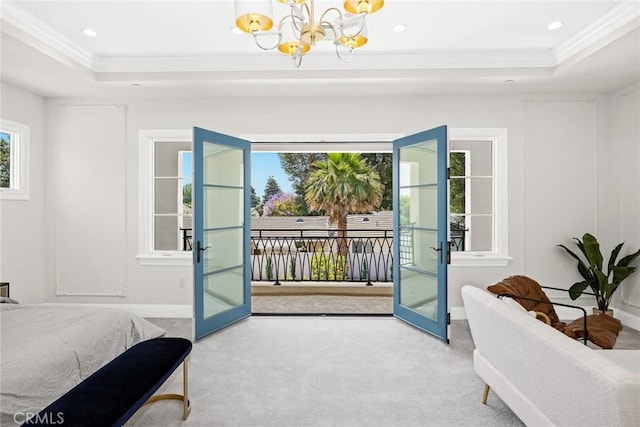 bedroom featuring a raised ceiling, access to exterior, french doors, and a chandelier