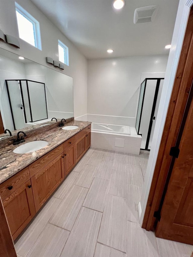 bathroom with vanity and shower with separate bathtub