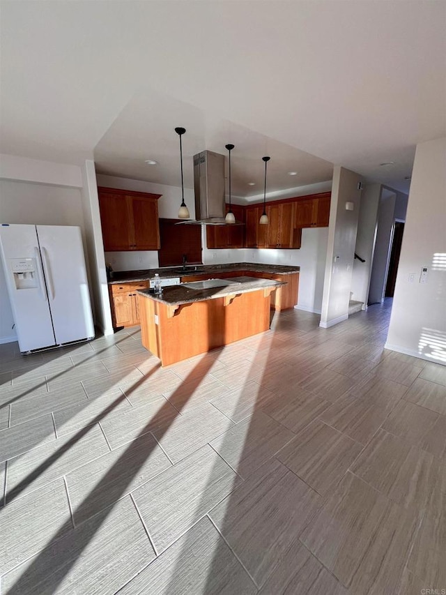 kitchen with a kitchen breakfast bar, pendant lighting, white fridge with ice dispenser, and a center island