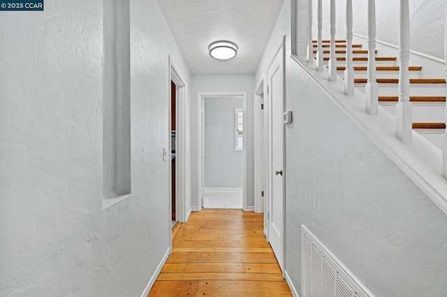 hallway with light hardwood / wood-style floors