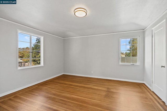 empty room with ornamental molding and hardwood / wood-style floors