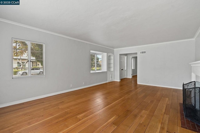 unfurnished living room featuring crown molding, a fireplace, and hardwood / wood-style floors