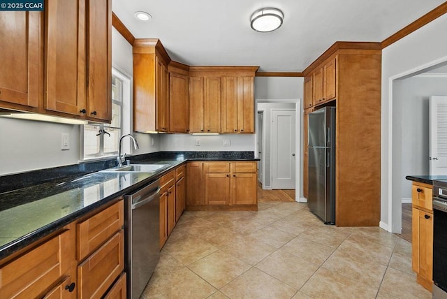 kitchen with appliances with stainless steel finishes, dark stone countertops, sink, light tile patterned flooring, and crown molding