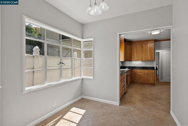 kitchen featuring light tile patterned flooring, dishwasher, and hanging light fixtures