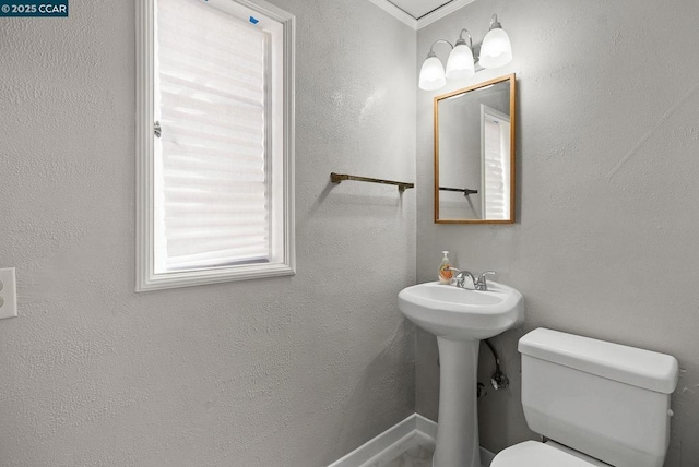 bathroom with toilet and ornamental molding