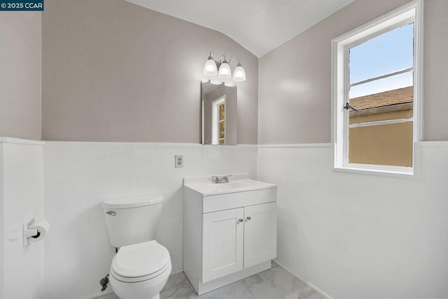 bathroom with toilet, vanity, and vaulted ceiling