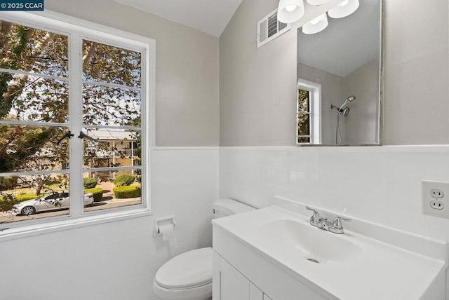 bathroom featuring toilet, plenty of natural light, and vanity