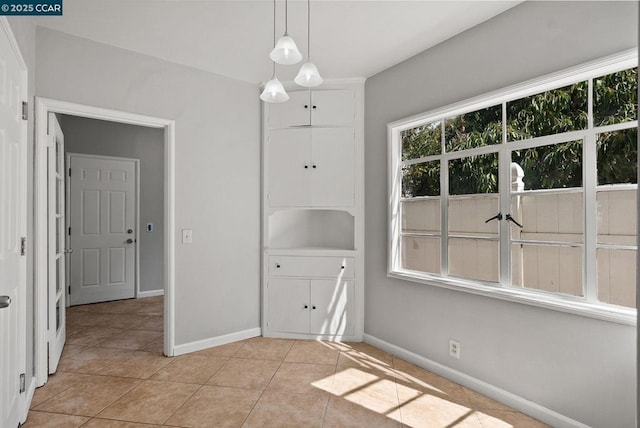 unfurnished dining area featuring light tile patterned floors