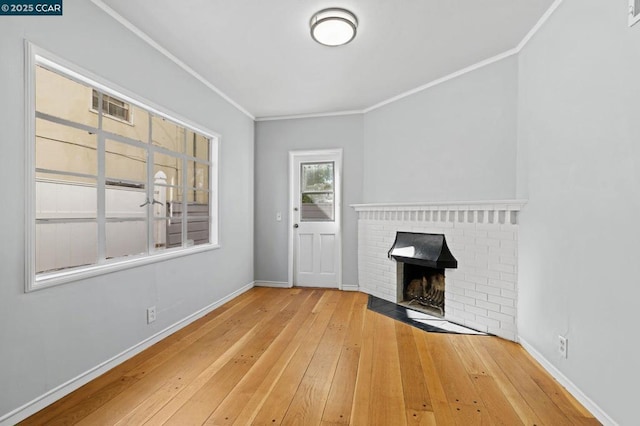 unfurnished living room featuring wood-type flooring, crown molding, and a fireplace