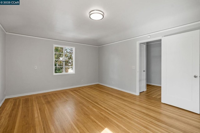 interior space with light wood-type flooring, a closet, and crown molding