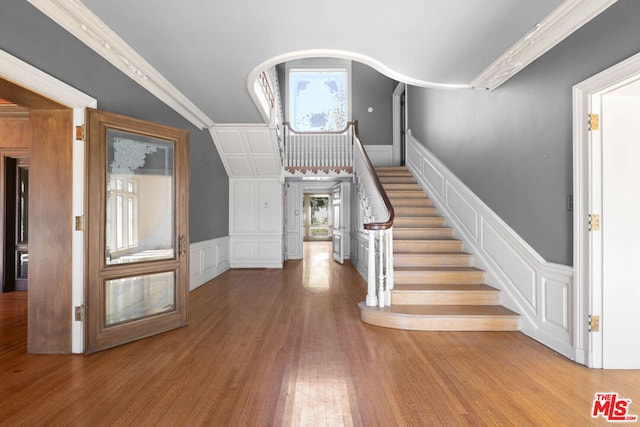 foyer featuring hardwood / wood-style floors and crown molding