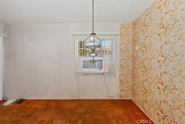 empty room featuring a textured ceiling, cooling unit, and dark colored carpet