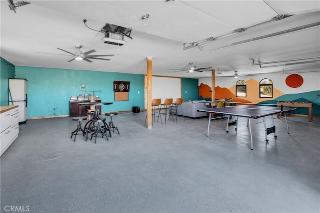 rec room with ceiling fan and concrete flooring