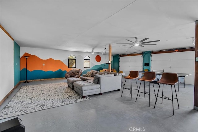 living room with ceiling fan and concrete floors