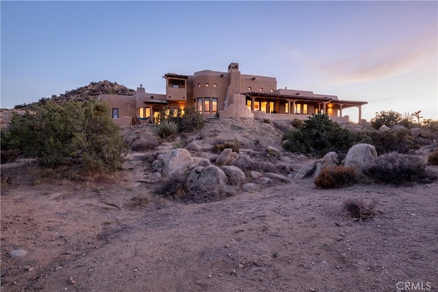 view of back house at dusk