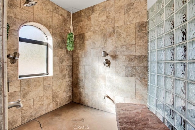 bathroom featuring concrete floors and tiled shower