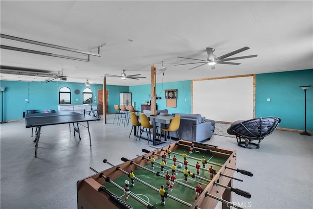 recreation room with ceiling fan and concrete floors