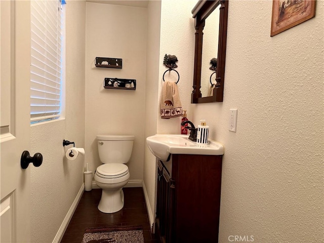 bathroom featuring toilet, vanity, and wood-type flooring