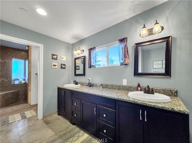 bathroom featuring walk in shower, vanity, and tile patterned flooring