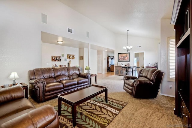 carpeted living room featuring high vaulted ceiling and a notable chandelier