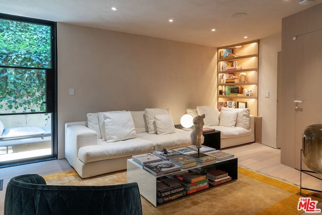 living room featuring light wood-type flooring and floor to ceiling windows