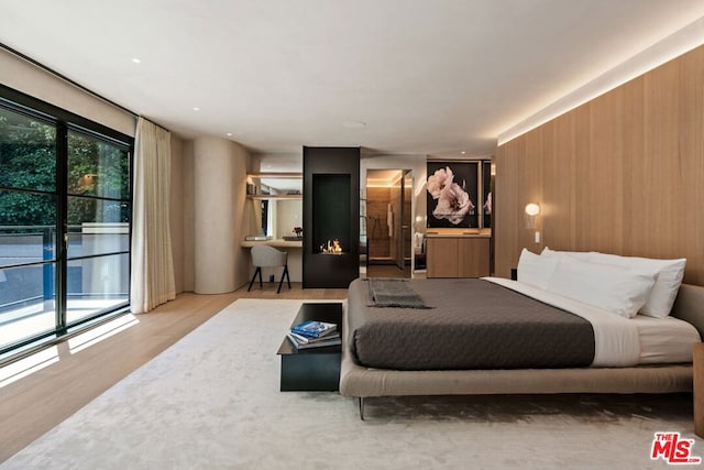 bedroom with access to outside and light wood-type flooring