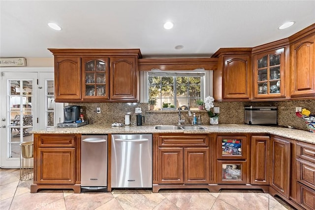 kitchen featuring light stone countertops, light tile patterned flooring, decorative backsplash, and sink