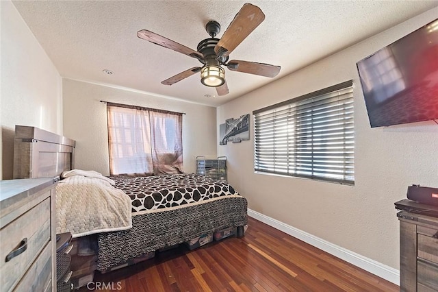 bedroom with a textured ceiling, ceiling fan, and dark hardwood / wood-style floors