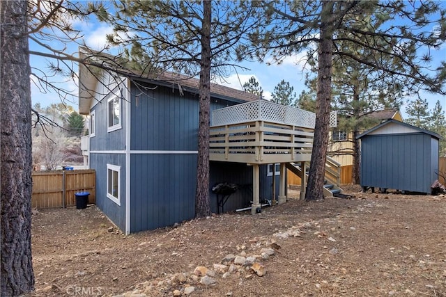 rear view of house featuring a deck and a storage unit