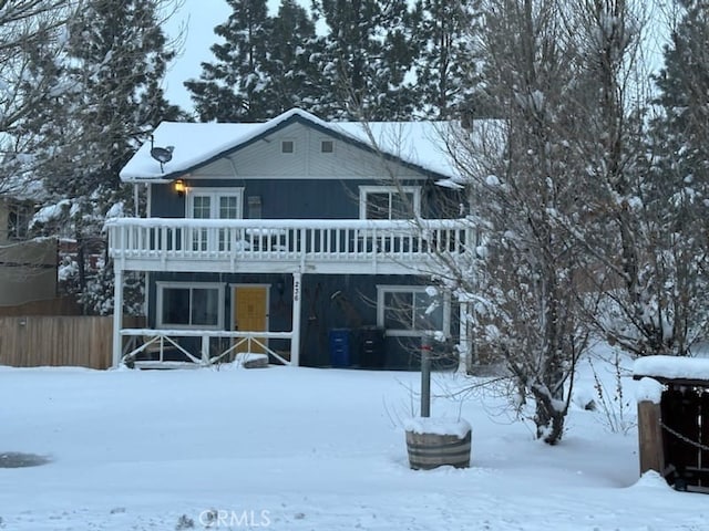 snow covered rear of property featuring a wooden deck