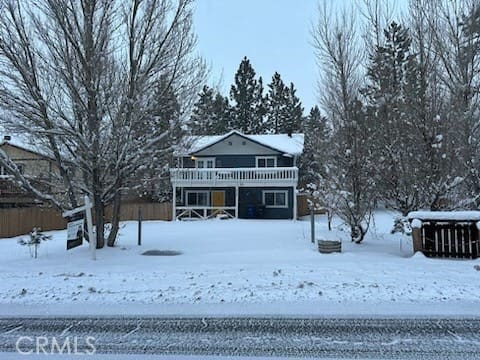 view of snow covered back of property