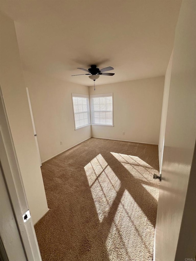 carpeted empty room featuring ceiling fan