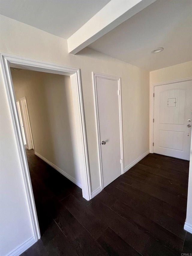 hall featuring dark hardwood / wood-style floors and beamed ceiling