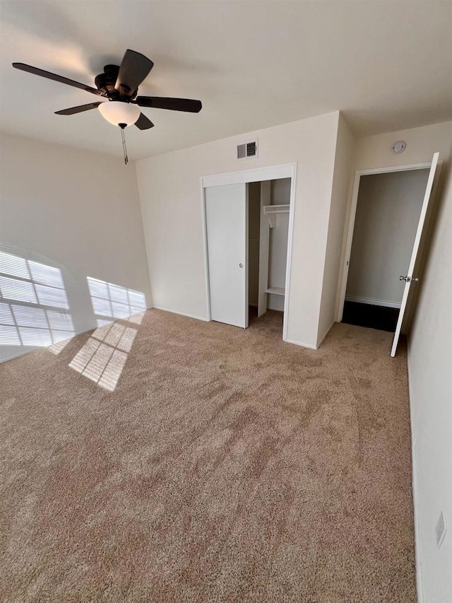 unfurnished bedroom with ceiling fan, a closet, and light carpet