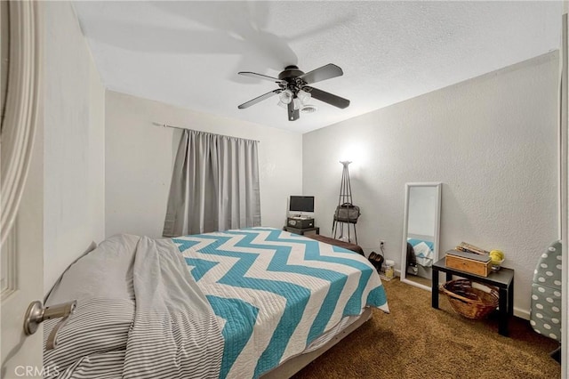 bedroom featuring ceiling fan, a textured ceiling, and dark colored carpet