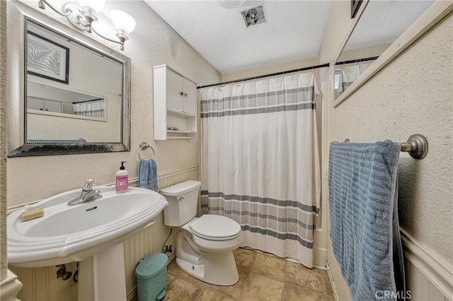 full bathroom featuring toilet, shower / bathtub combination with curtain, and sink