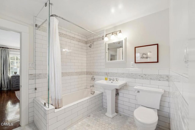 bathroom featuring shower / bath combo with shower curtain, tile walls, tile patterned floors, and toilet