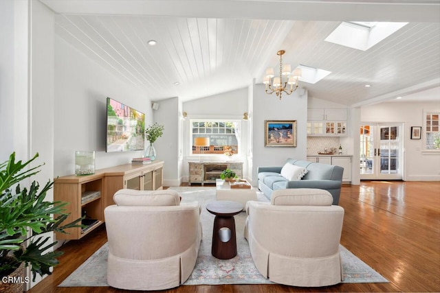 living room with vaulted ceiling with skylight, wood ceiling, a chandelier, and hardwood / wood-style floors