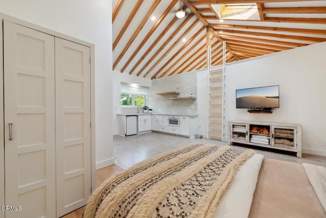 living room with light hardwood / wood-style flooring and vaulted ceiling with beams