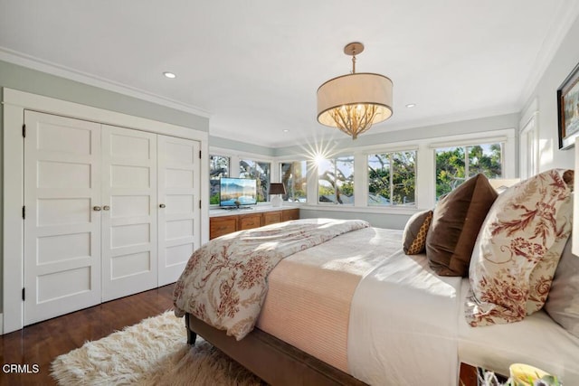 bedroom featuring a closet, dark hardwood / wood-style flooring, and crown molding