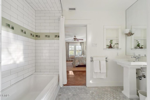 bathroom featuring ceiling fan, tile patterned floors, and shower / bath combo with shower curtain