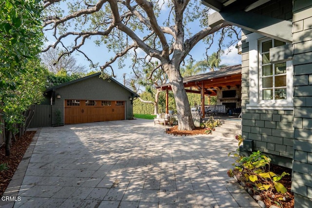 view of patio / terrace with a garage and an outbuilding