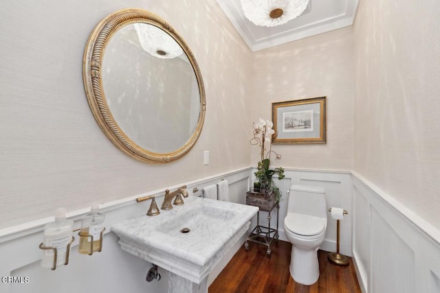 bathroom featuring toilet, crown molding, and hardwood / wood-style floors