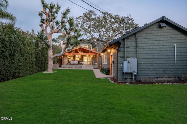 back of property with a patio area and a lawn