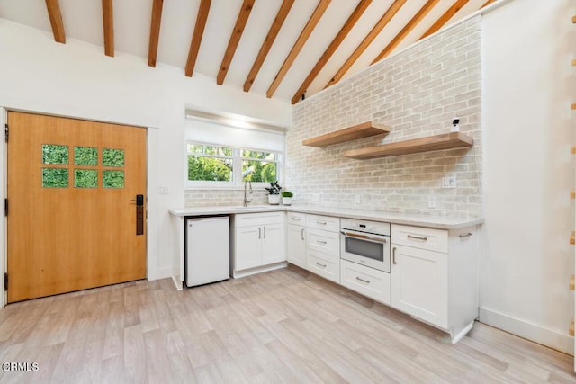 kitchen featuring sink, light hardwood / wood-style flooring, white cabinets, and white appliances