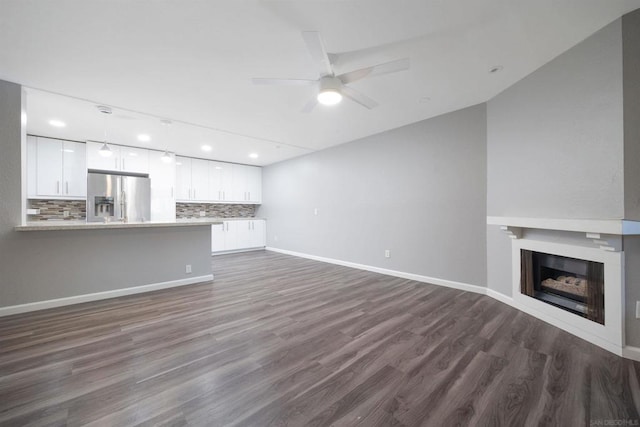 unfurnished living room with ceiling fan and dark hardwood / wood-style flooring